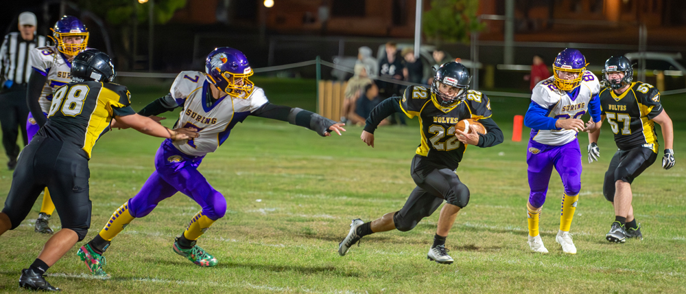 Algoma quarterback Grant Vandervest cuts between two defenders and heads upfield in the Wolves 52-20 win over Suring on Thursday, October. 13.