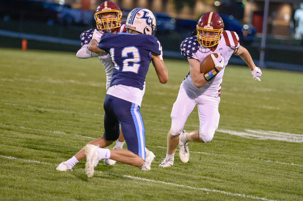 With teammate Sawyer Dorn blocking a Little Chute defender, Trace Schoenebeck heads upfield during L-C’s win over the Mustangs in week five.