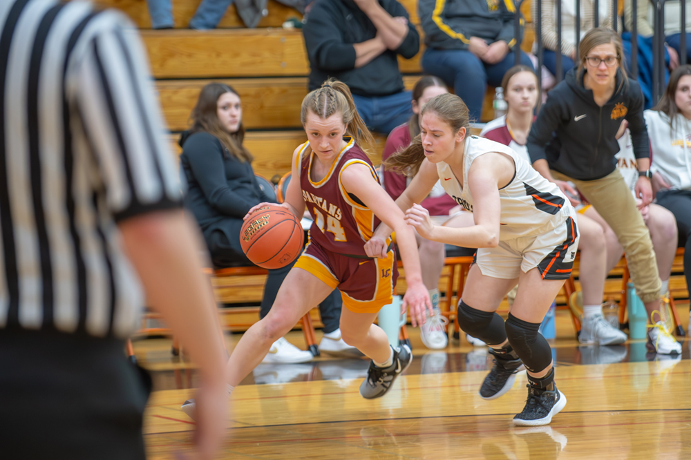 With head coach Beth Budnik watching intently from the sidelines, L-C’s Sienna Blohowiak gets around her defender along the baseline and heads for the basket