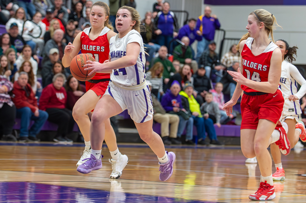 Kewaunee’s Braelyn Chevalier gets a step on a pair of Valders defenders on her way to the basket and two of her six points 